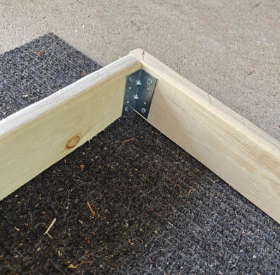 one corner of a wooden frame, held together with a bracket.