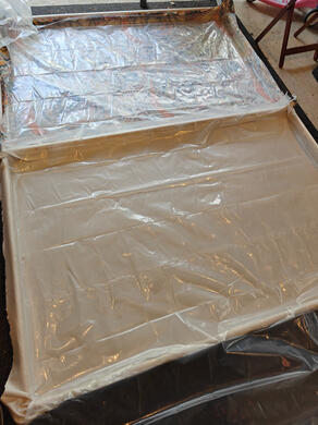 one wooden flat, on the floor, with cloth stapled across it facing down, and plastic sheeting stapled underneath.