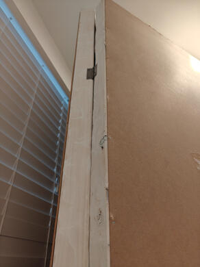 the edges of two wooden frames, attached together by a hinge.